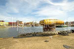 bollard in a seaport with corsair in the background