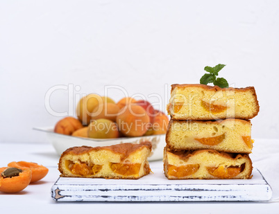 baked square pieces of cake sponges with fresh apricots