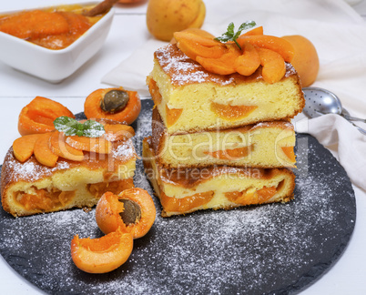 square pieces of apricot pie on a black graphite plate