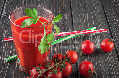 Glass of tomato juice on wooden table