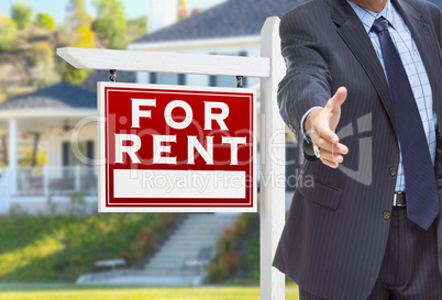 Male Agent Reaching for Hand Shake in Front of For Rent Sign and