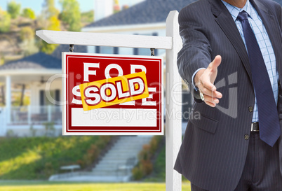 Male Agent Reaching for Hand Shake in Front of Sold For Sale Sig