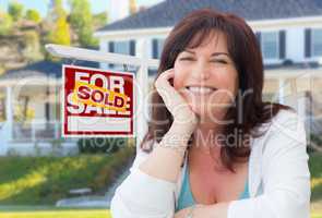Middle Aged Woman In Front of House with Sold For Sale Real Esta