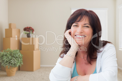 Middle Aged Woman Relaxing Inside Empty Room With Moving Boxes