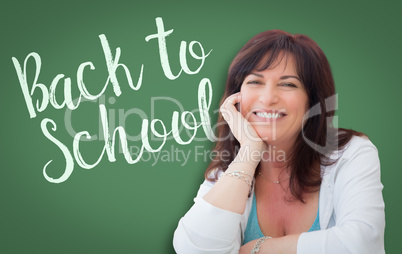 Back To School Written On Green Chalkboard Behind Smiling Middle