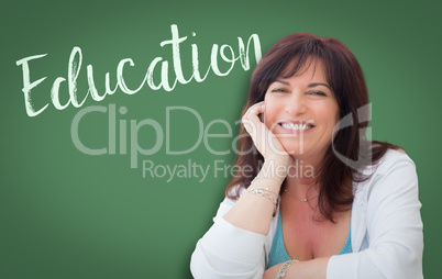 Education Written On Green Chalkboard Behind Smiling Middle Aged