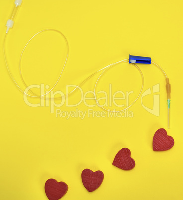 plastic catheter with needle and red heart