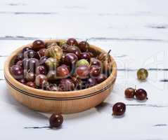 ripe red berries of gooseberries in a brown  bowl