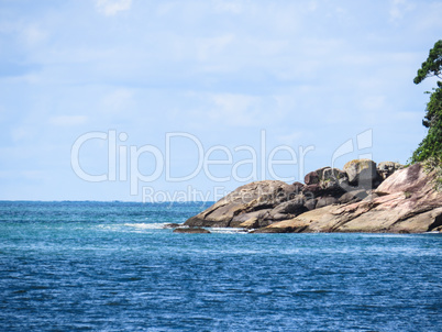 Shore of rocks in the sea with blue sky.