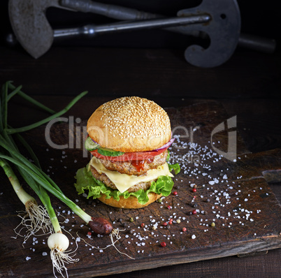 sandwich with two meat cutlets, cheese and vegetables