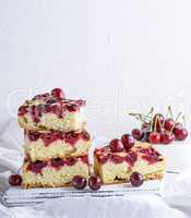 baked square pieces of a biscuit pie with cherries