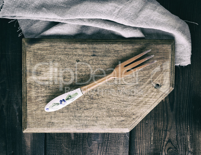 vintage wooden fork on a rectangular brown kitchen cutting board