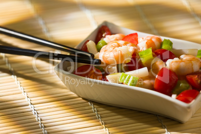 Shrimp salad inside a white bowl and chopsticks
