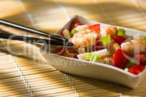 Shrimp salad inside a white bowl and chopsticks