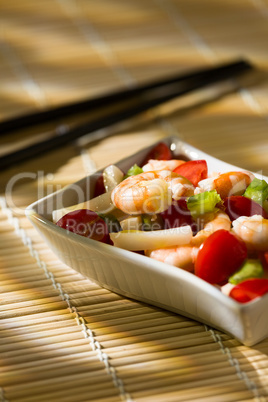 Shrimp salad on a bamboo tablecloth and chopsticks