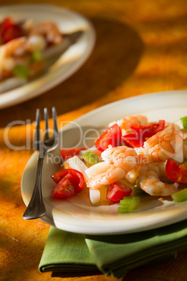 Shrimp salad with squid tomatoes and celery over a green napkin