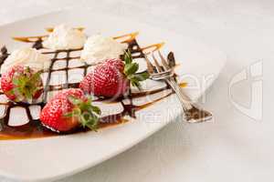 Strawberries with cream on a square plate