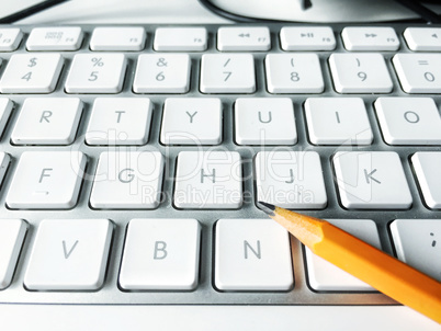 Pencil over a white computer keyboard