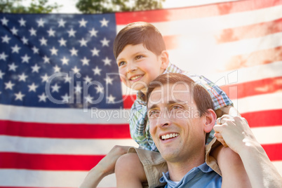 Father with Son Piggy Back Riding In Front of American Flag