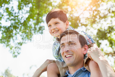 Mixed Race Father and Son Playing Piggyback Together in the Park