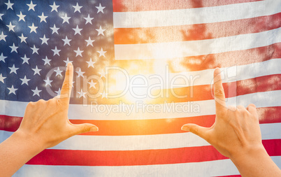 Hands Framing Sun Shining Through American Flag