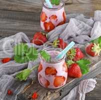 strawberry yogurt in a glass jar with a plastic straw