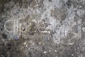 fragment of an old gray cement wall with black stones