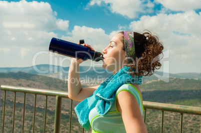 After an intense sport, a girl drinks water with pleasure