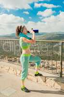 The girl after a long run drinks cold water from a thermos