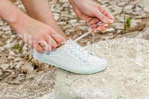 Woman laces white sneakers