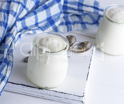 homemade yogurt in a glass jar on a white wooden board