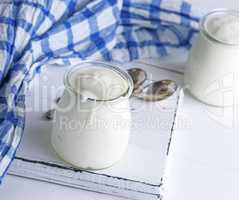 homemade yogurt in a glass jar on a white wooden board
