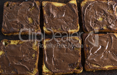 square pieces of fried white bread smeared with chocolate