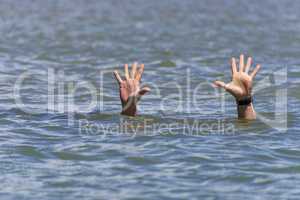 pair of masculine hands sticks out of the sea water