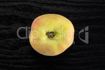 Fresh raw saturn peach on black wood