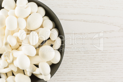 Fresh raw white shimeji mushroom on grey wood