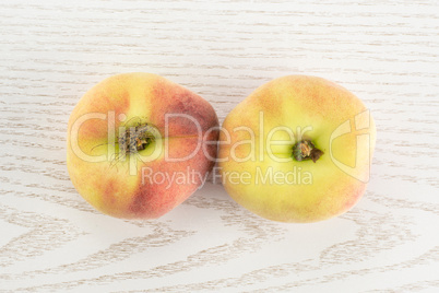 Fresh raw saturn peach on grey wood