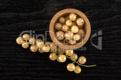 Fresh white currant berries on black wood