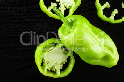 Fresh raw light green pepper on black wood