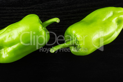 Fresh raw light green pepper on black wood