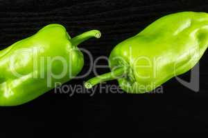 Fresh raw light green pepper on black wood