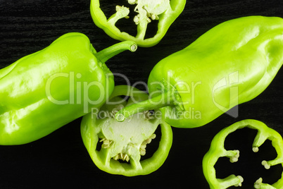 Fresh raw light green pepper on black wood