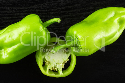 Fresh raw light green pepper on black wood