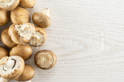 Fresh raw brown champignons on grey wood