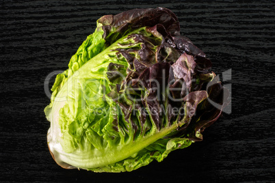 Fresh raw lettuce red little gem on black wood