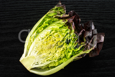 Fresh raw lettuce red little gem on black wood