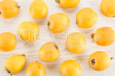 Fresh raw orange japanese loquat on grey wood