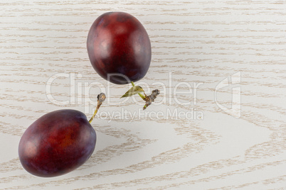 Fresh Raw vibrant plums on grey wood