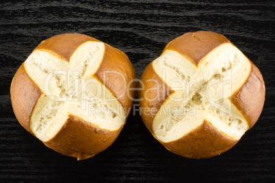 Fresh Bavarian bread bun on black wood