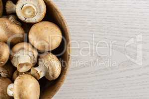 Fresh raw brown champignons on grey wood